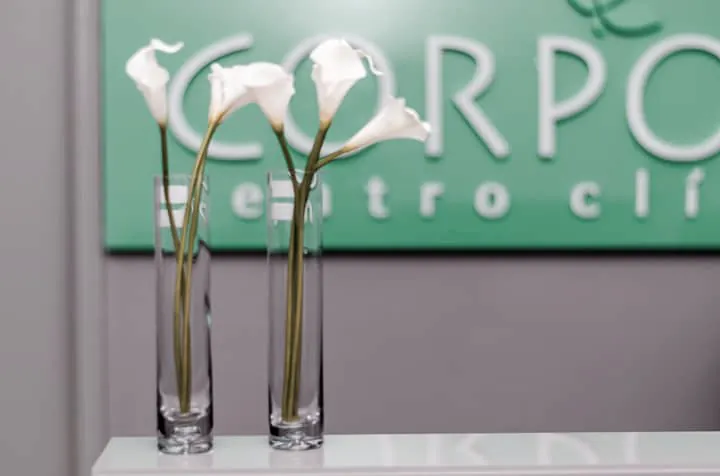 Copos-de-leite sobre o balcão da recepção, com a placa da clínica ao fundo