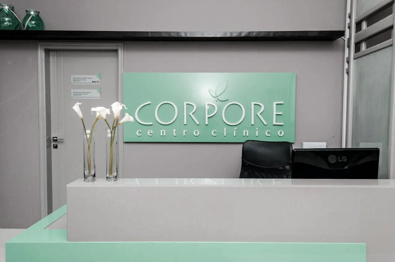 Balcão da recepção do Instituto Corpore com arranjo de copos-de-leite